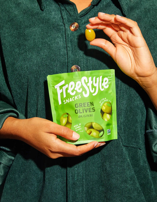 Woman holding a pack of Freestyle Green Olives
