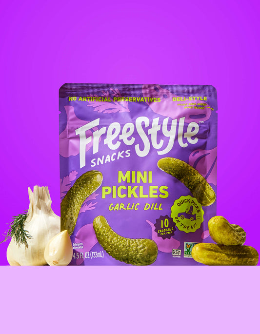 Freestyle Snacks Garlic Dill Mini Pickles packaging on a purple background