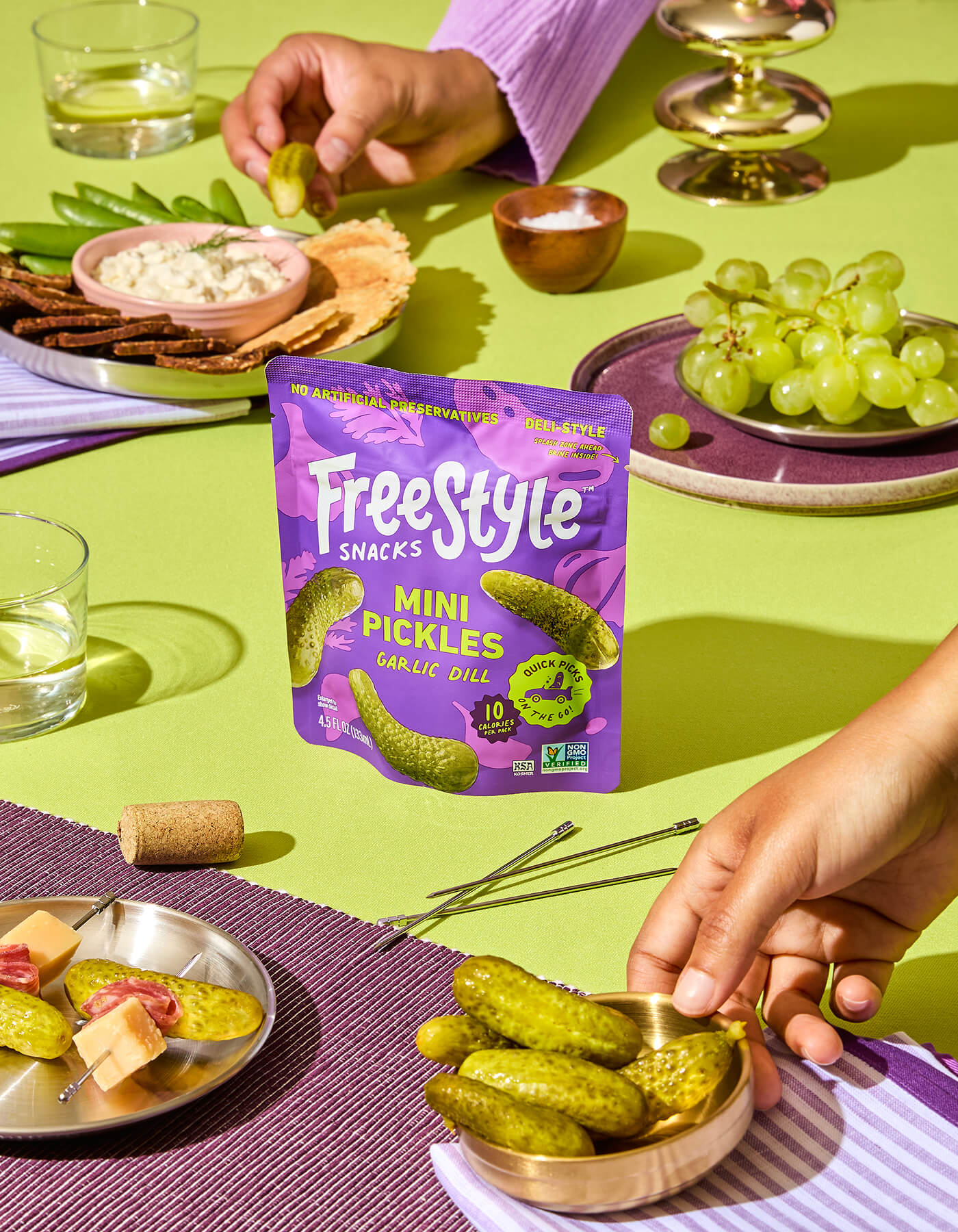 Freestyle Snacks Mini Pickles Garlic Dill package on a table with snacks and drinks.