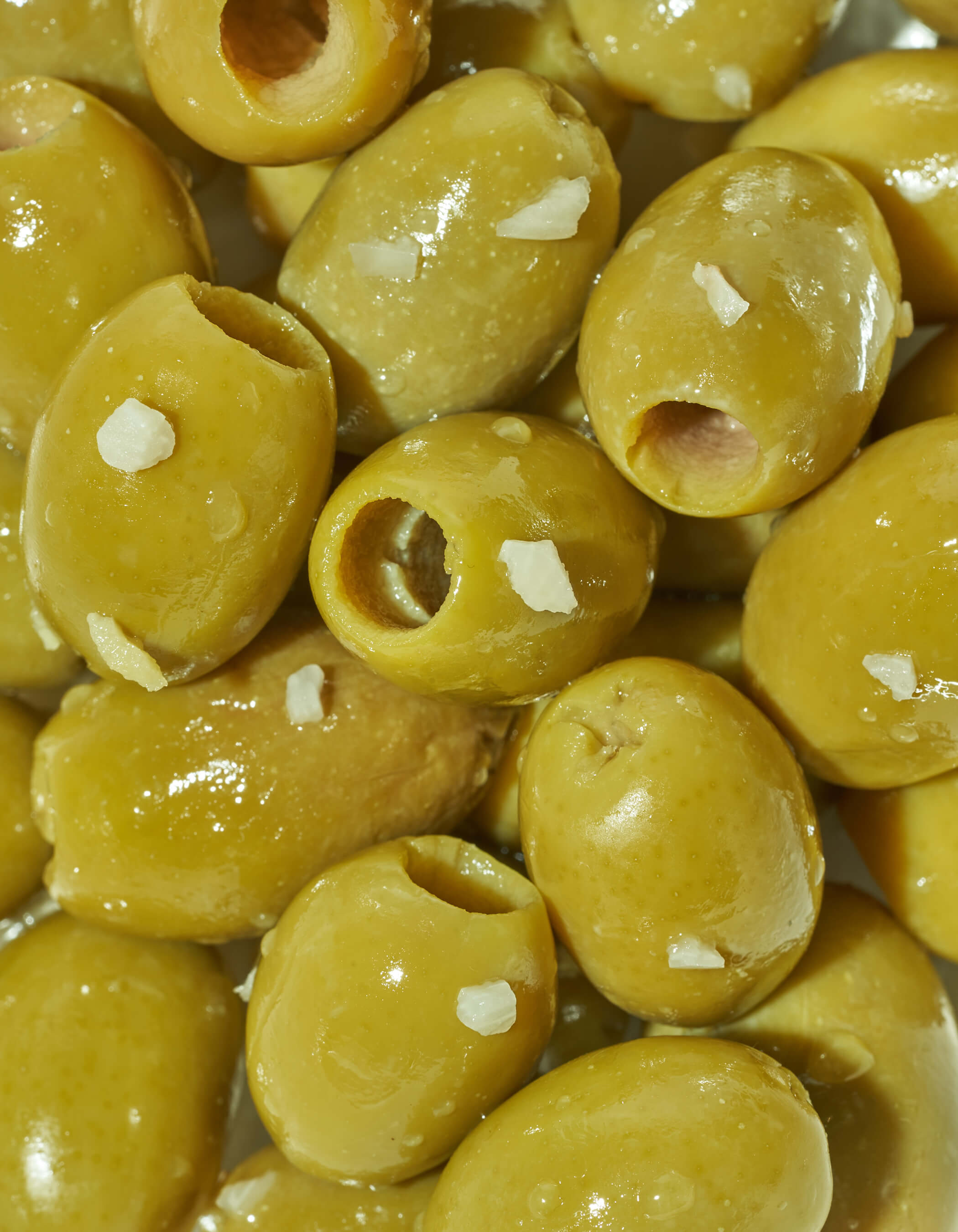 Close-up of green olives with garlic specks.