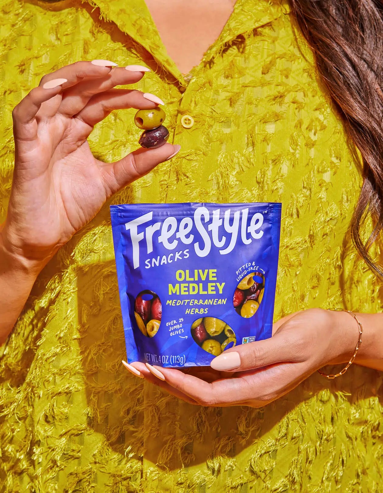 Woman holding a pack of Freestyle Olive Medley Olives