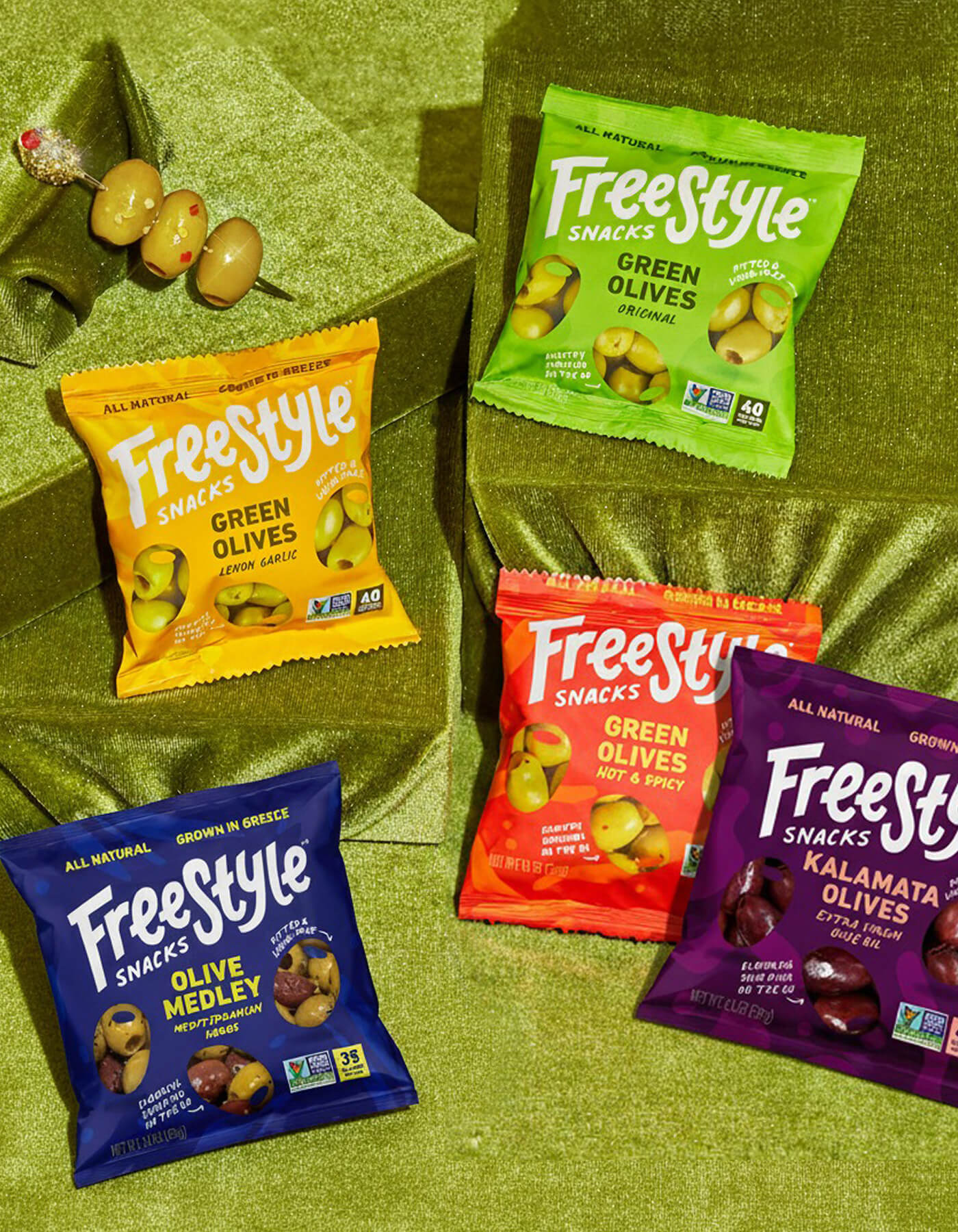 Assorted single-serve Freestyle Snacks packages on a green surface
