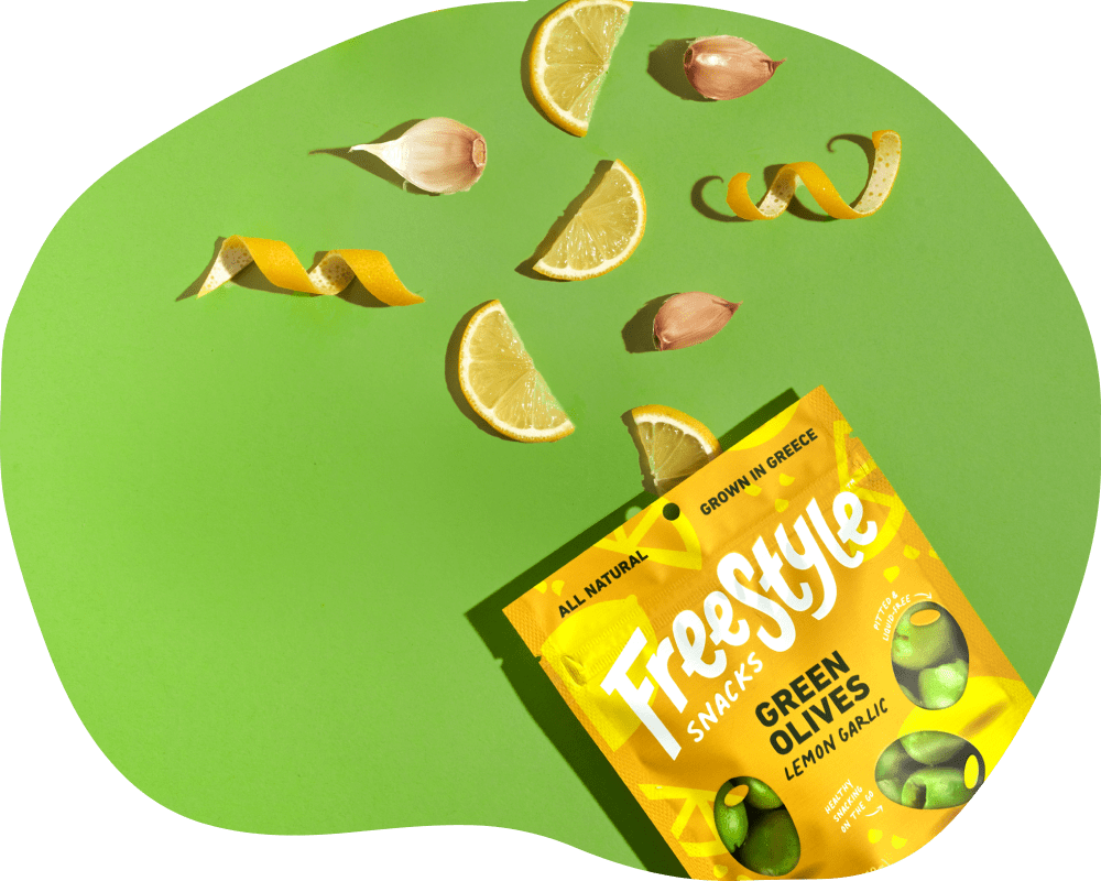 Freestyle Snacks Green Olives Lemon Garlic package with lemon slices and garlic cloves on a green background